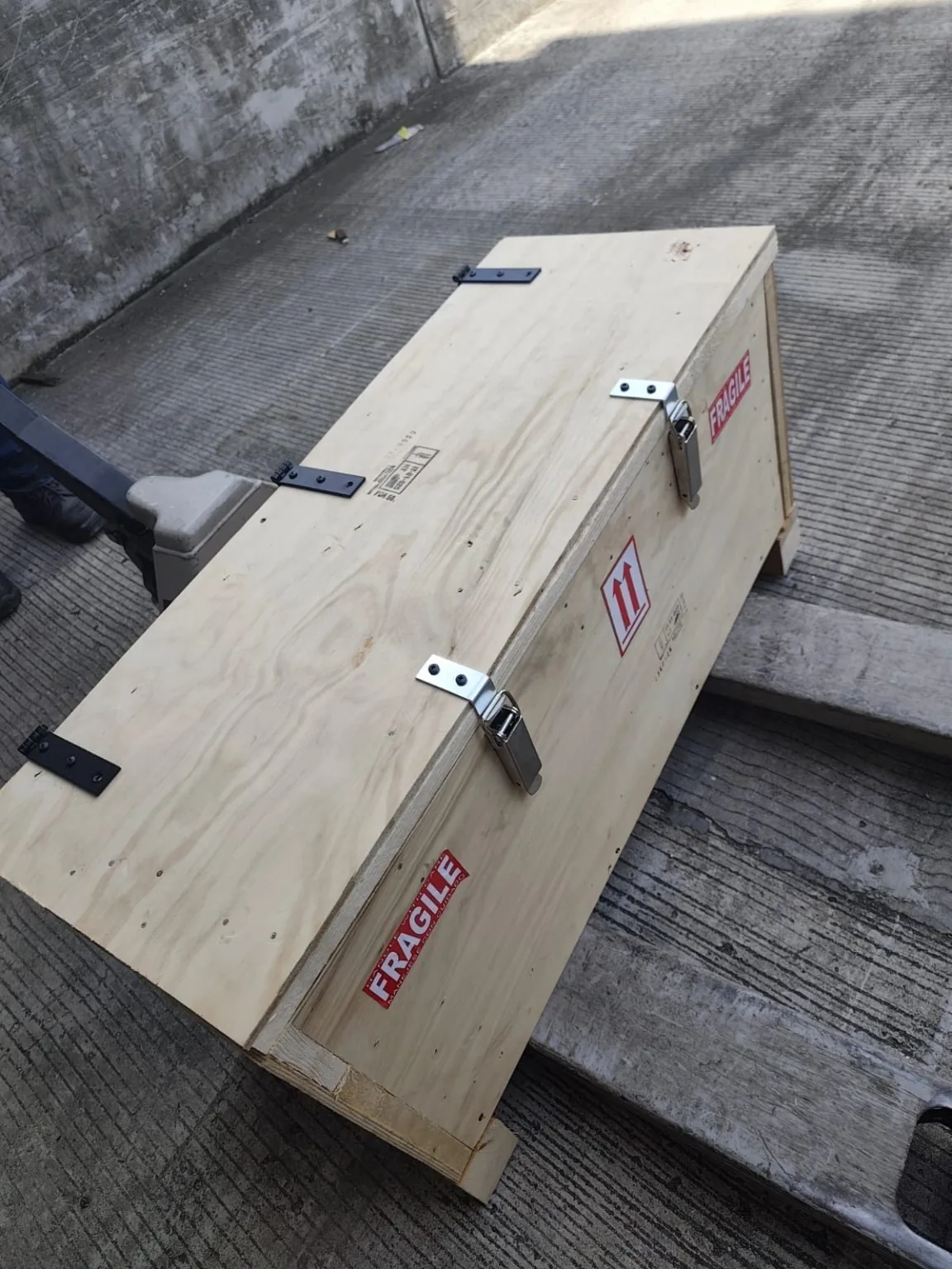 Caja de madera cerrada y señalizada como carga frágil